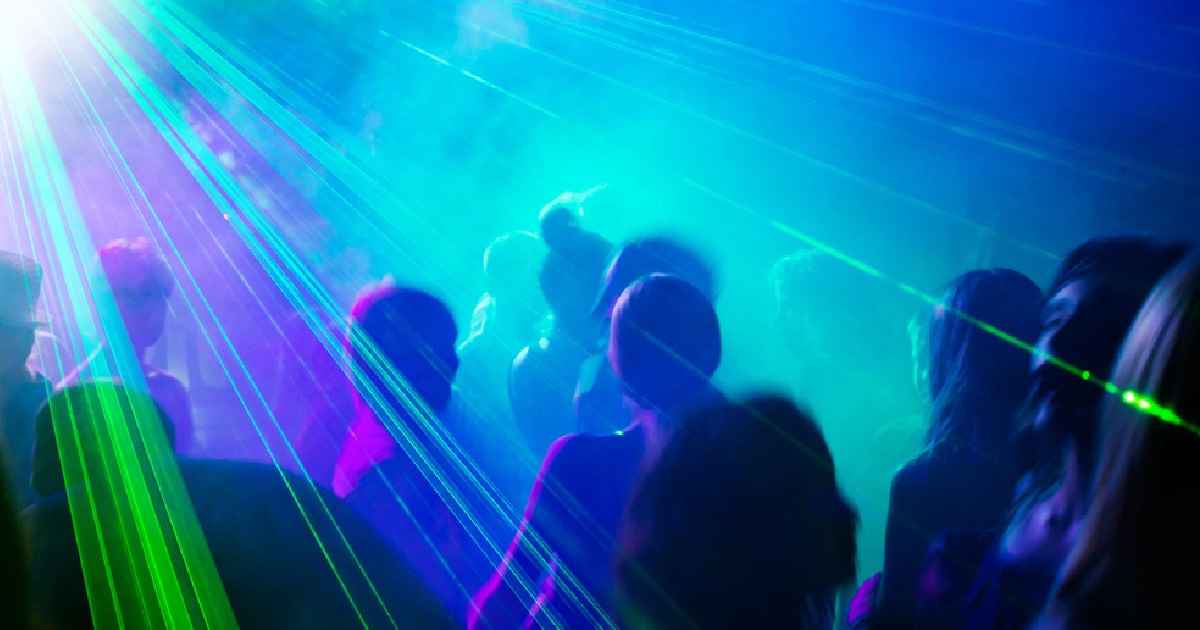 Dancing under laser lights at night club