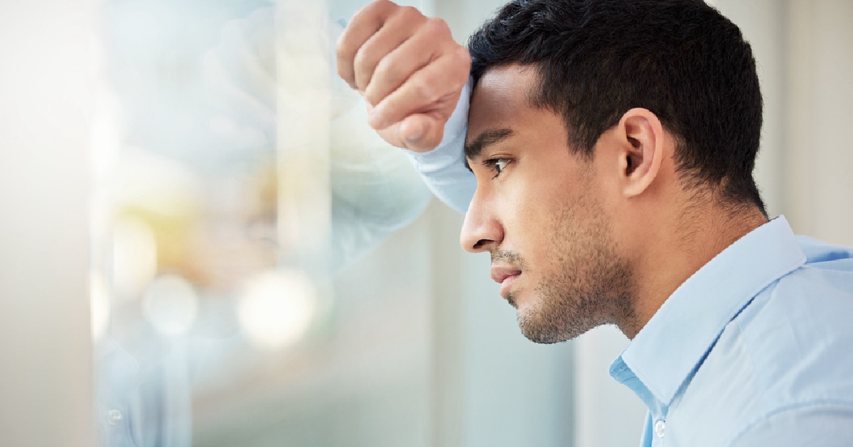 Man looking out window looking concerned 