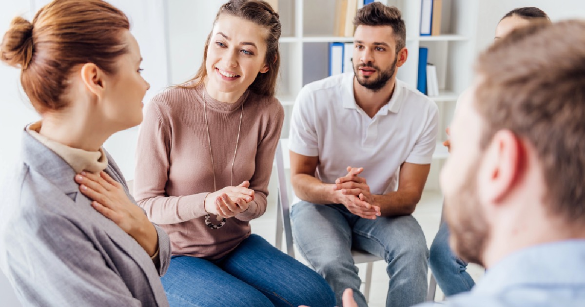 Group of people applauding a member for sharing in therapy