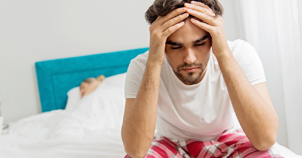 Young man having trouble falling asleep 