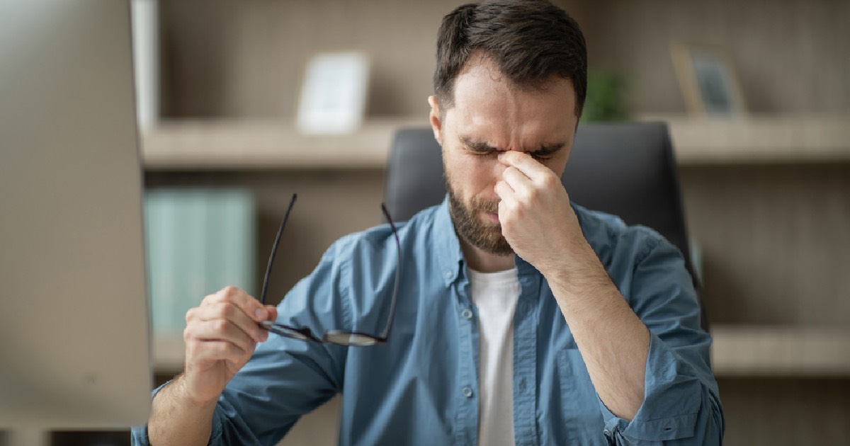 Tired man sitting at desk during long work day