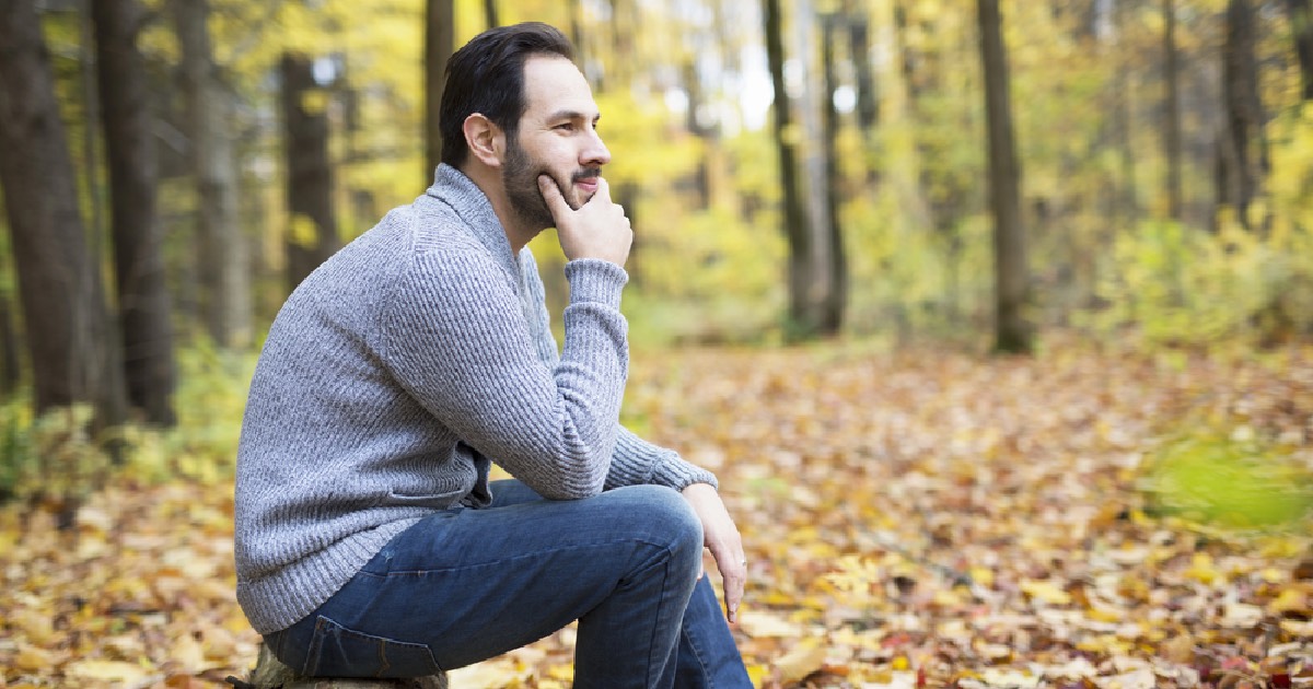 Middle-aged man sitting outdoors during autumn