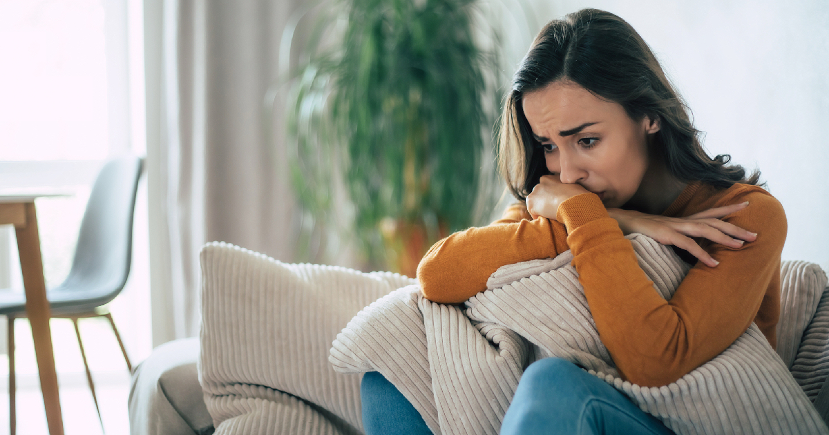 Woman looking sad and hugging pillow