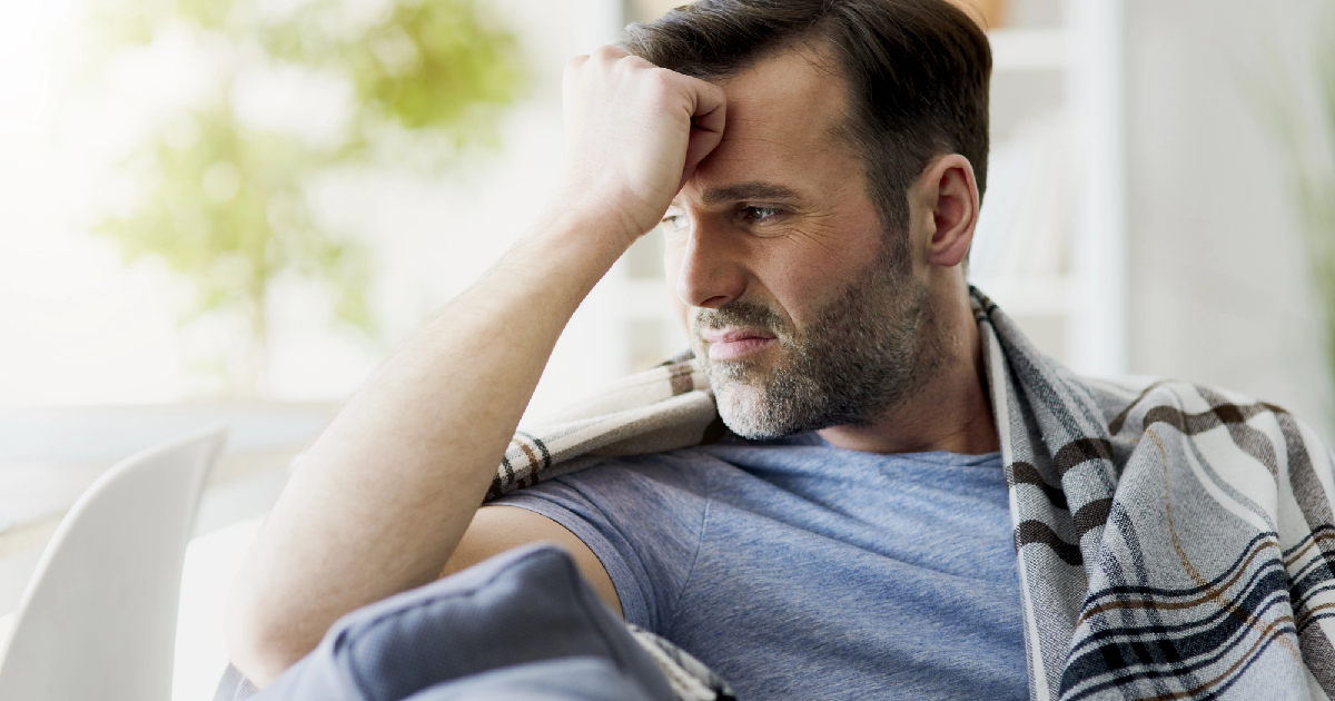 Man sitting at home with headache