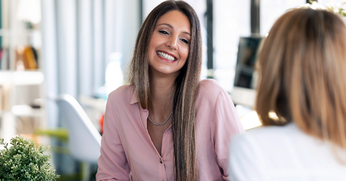 Happy young businesswoman talking to therapist 