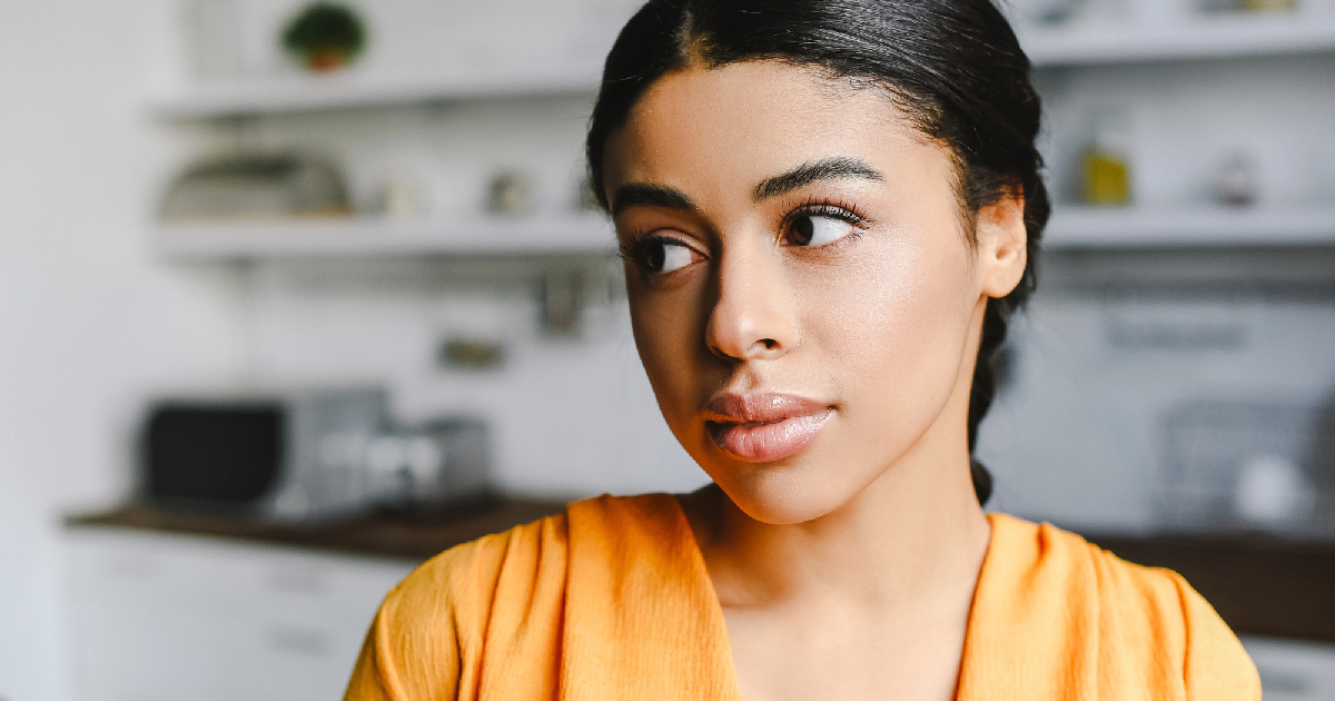 Young girl wearing orange shirt looking serious 