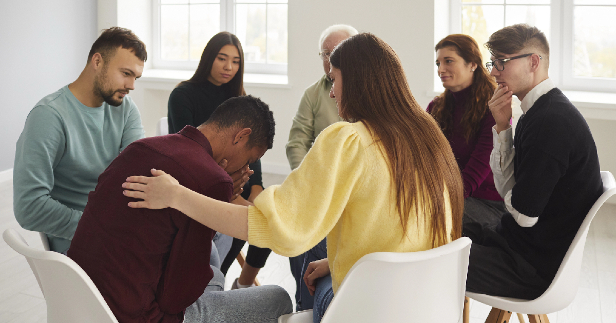 Group of people comforting and supporting one another