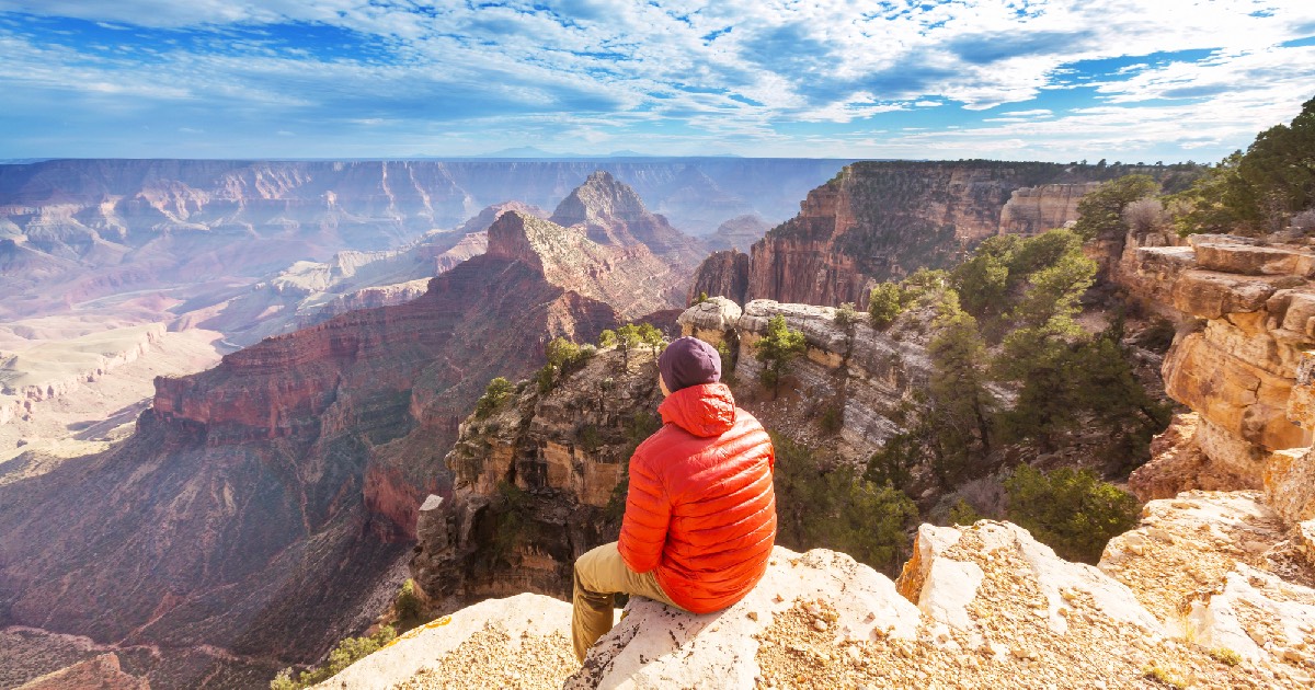 Man sitting and looking out at the Grand Canyon