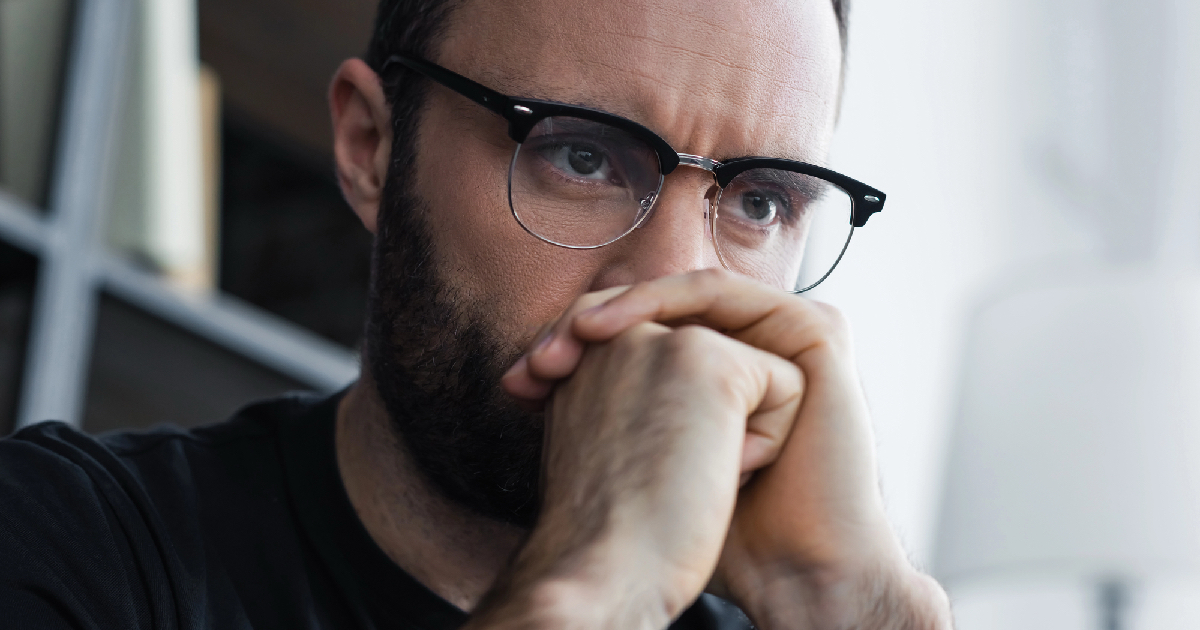 Man with hands folded looking sad