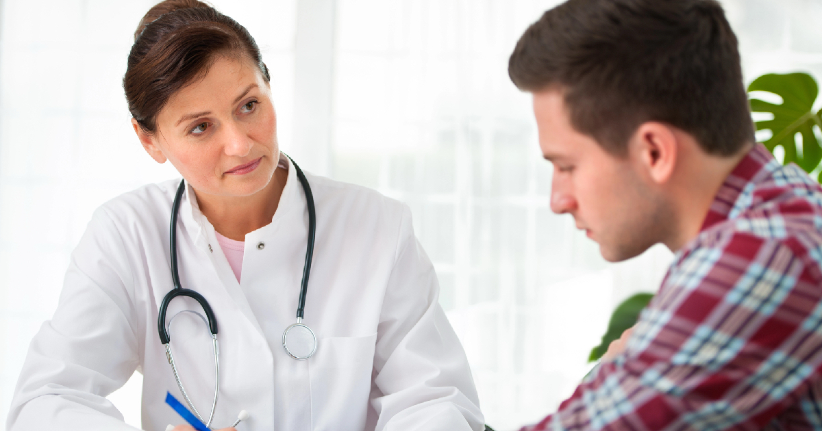 Young man sitting with doctor receiving medications 