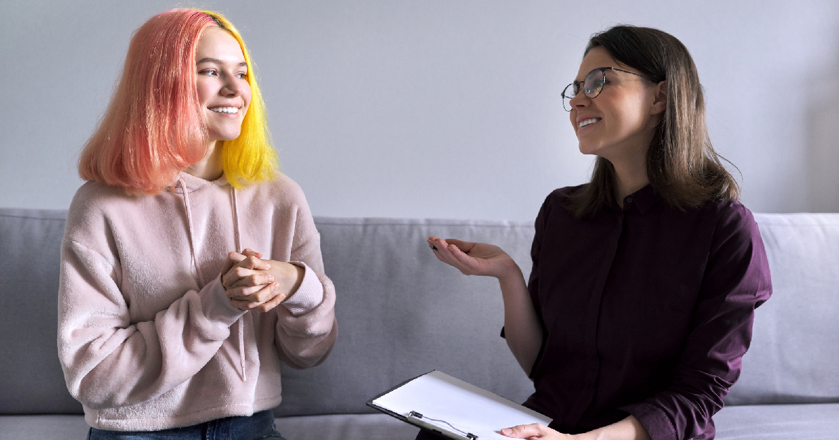 Two women sitting on couch talking about mental health