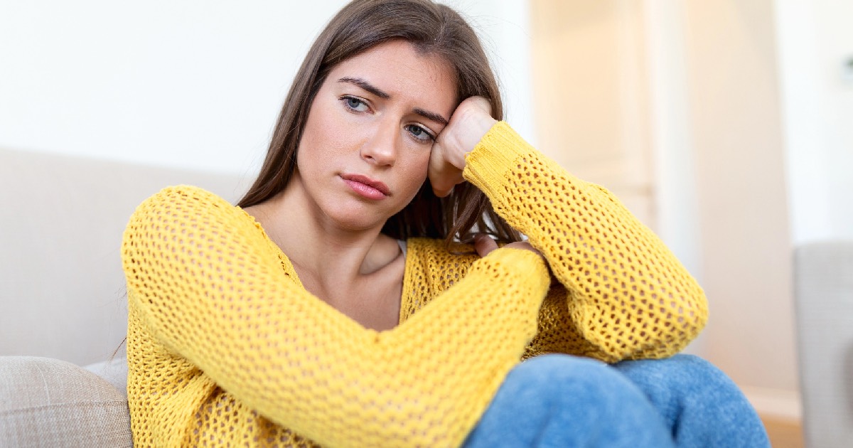 Woman wearing bright yellow shirt looking nervous