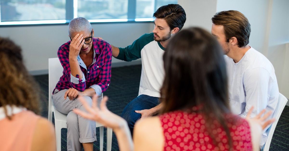 Group therapy with members consoling upset person